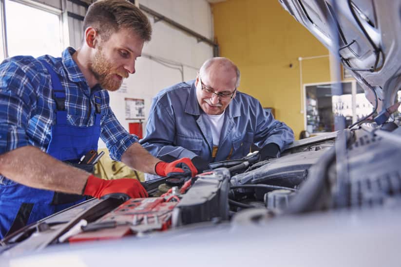mechanics-repairing-car-workshop